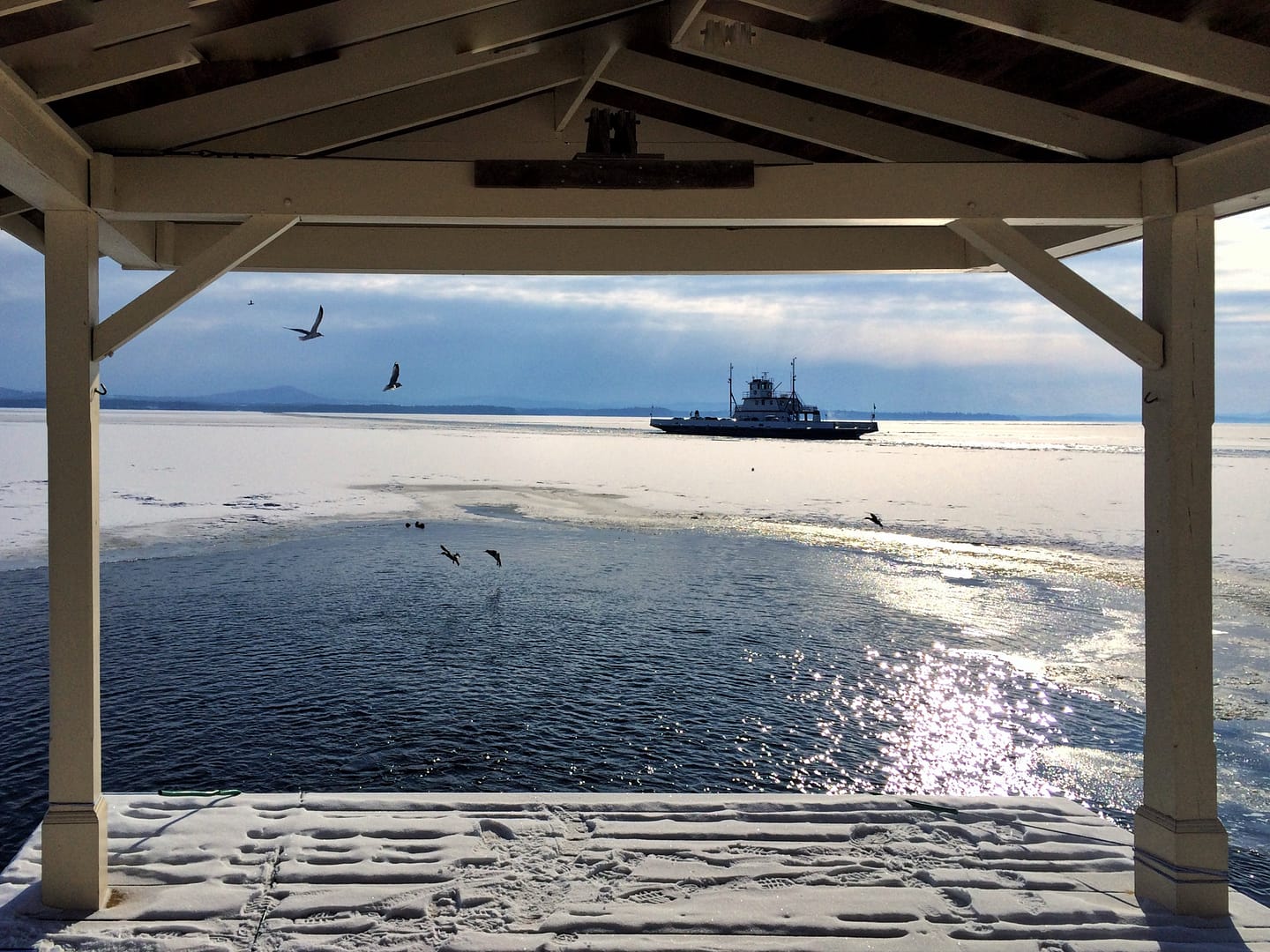 Ferry & Ice: view from Rosslyn boathouse overlooking duck pond, and Essex-Charlotte ferry icebreaking a channel through frozen Lake Champlain, on February 10, 2014. (Photo: Geo Davis)