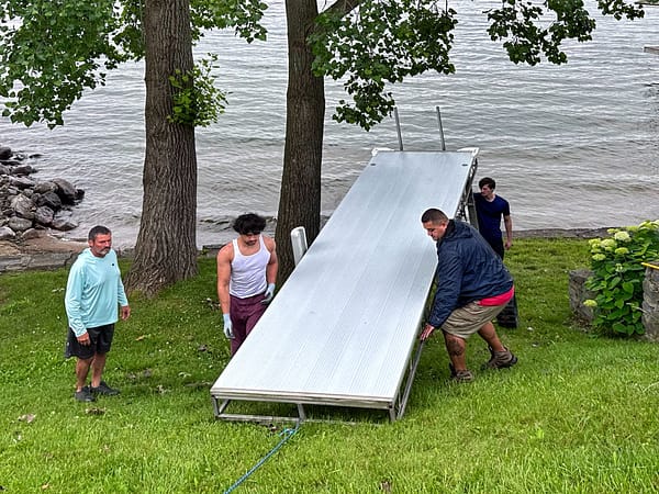 Glen, Tomasi, Supi, and Erik Lowering a Dock Section (Photo: Geo Davis)